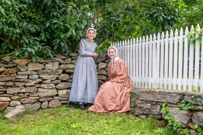 两个学生穿着19世纪30年代的衣服, 在老斯特布里奇村做口译员实习.