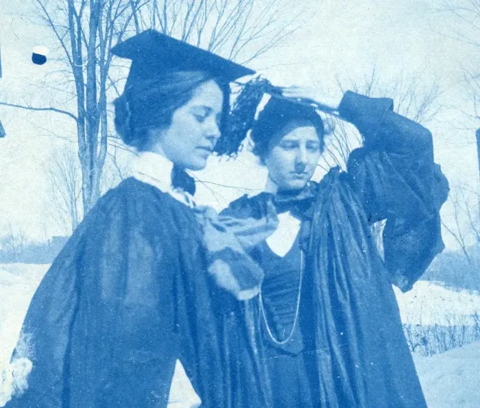1895届的两名学生在集会日戴着帽子，穿着长袍.