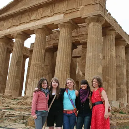 学生们在意大利古代遗迹前摆姿势的照片